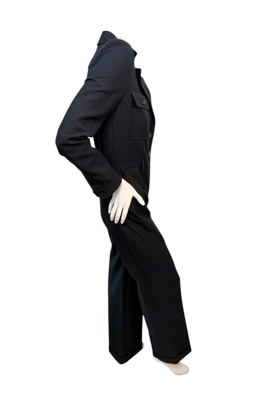 Side angle view of Saint Laurent FW22 black wool jumpsuit showing contoured waist and elongated leg line.