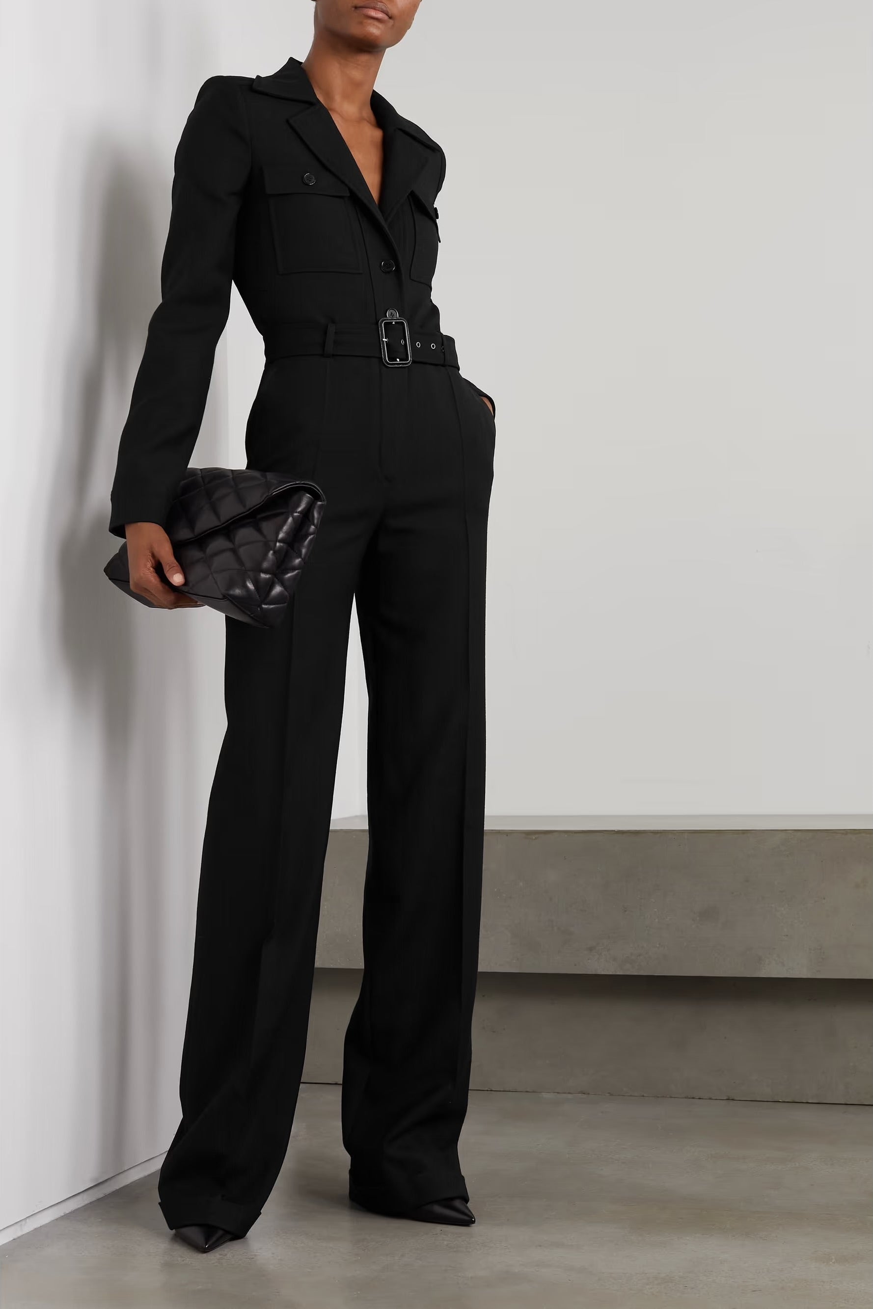 Styled view of Saint Laurent FW22 black tailored jumpsuit styled on model, emphasizing sleek silhouette and tailoring.