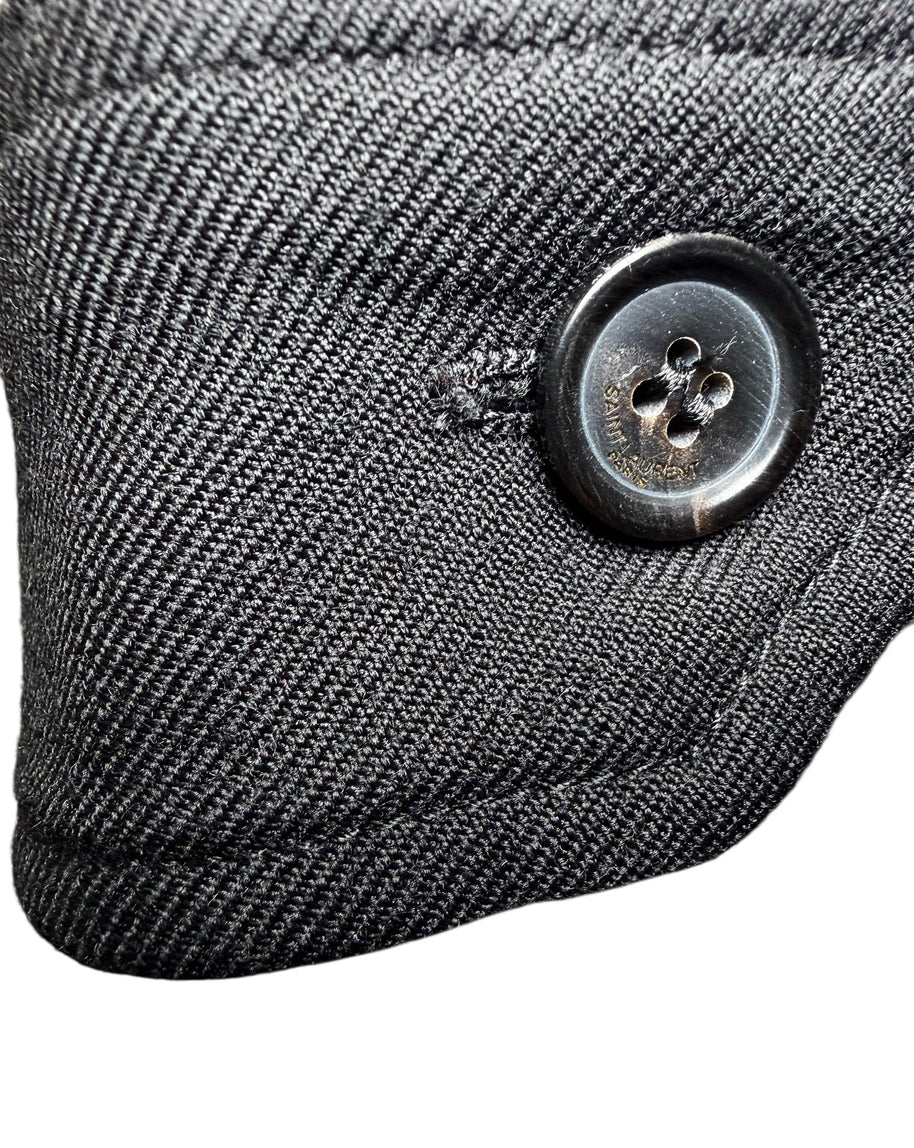 Macro close-up of Saint Laurent Paris branded black button on tailored wool jumpsuit.