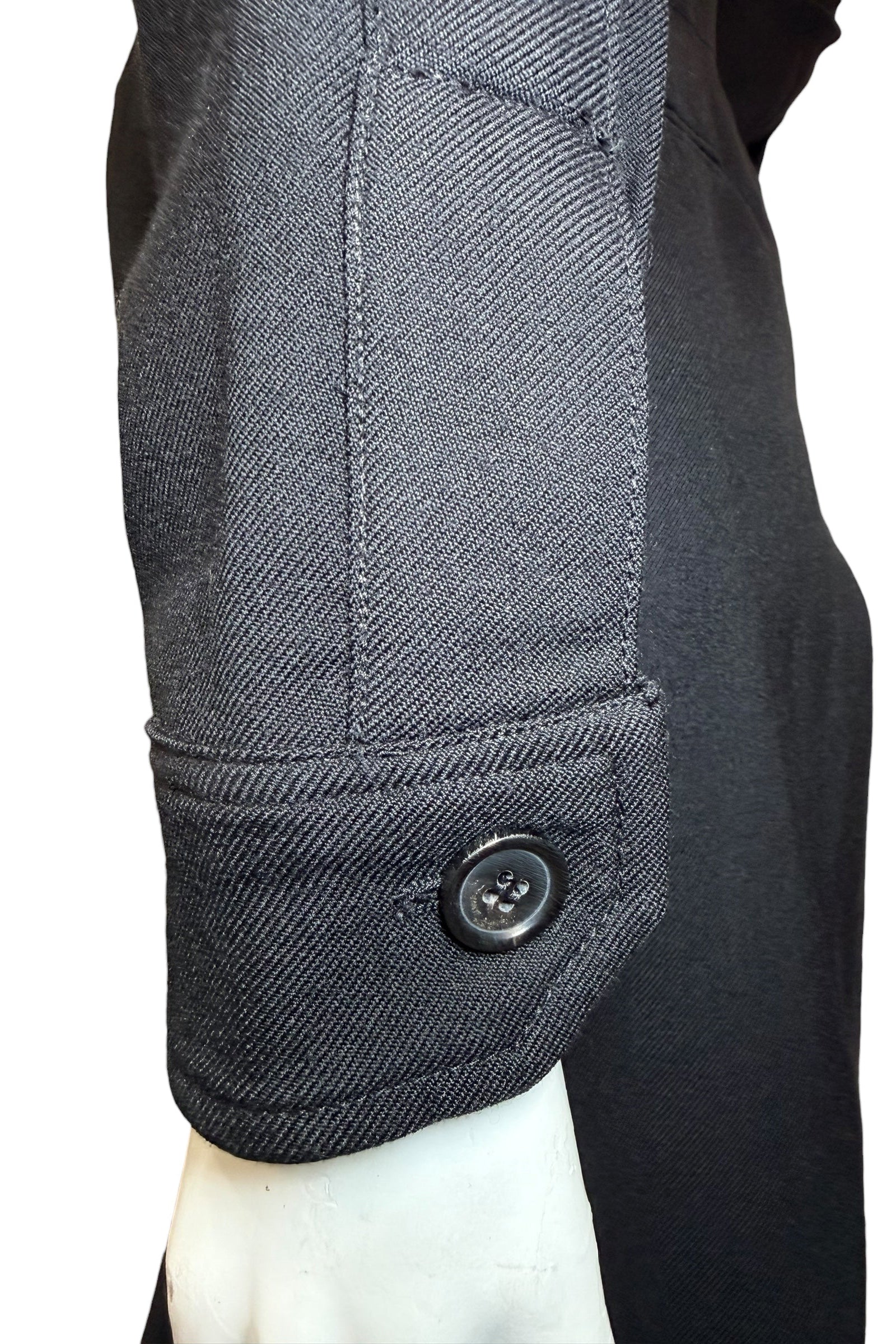 Sleeve cuff detail of Saint Laurent Paris black wool jumpsuit with signature branded button.