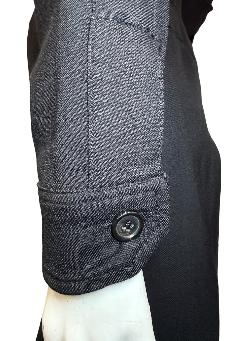 Sleeve cuff detail of Saint Laurent Paris black wool jumpsuit with signature branded button.