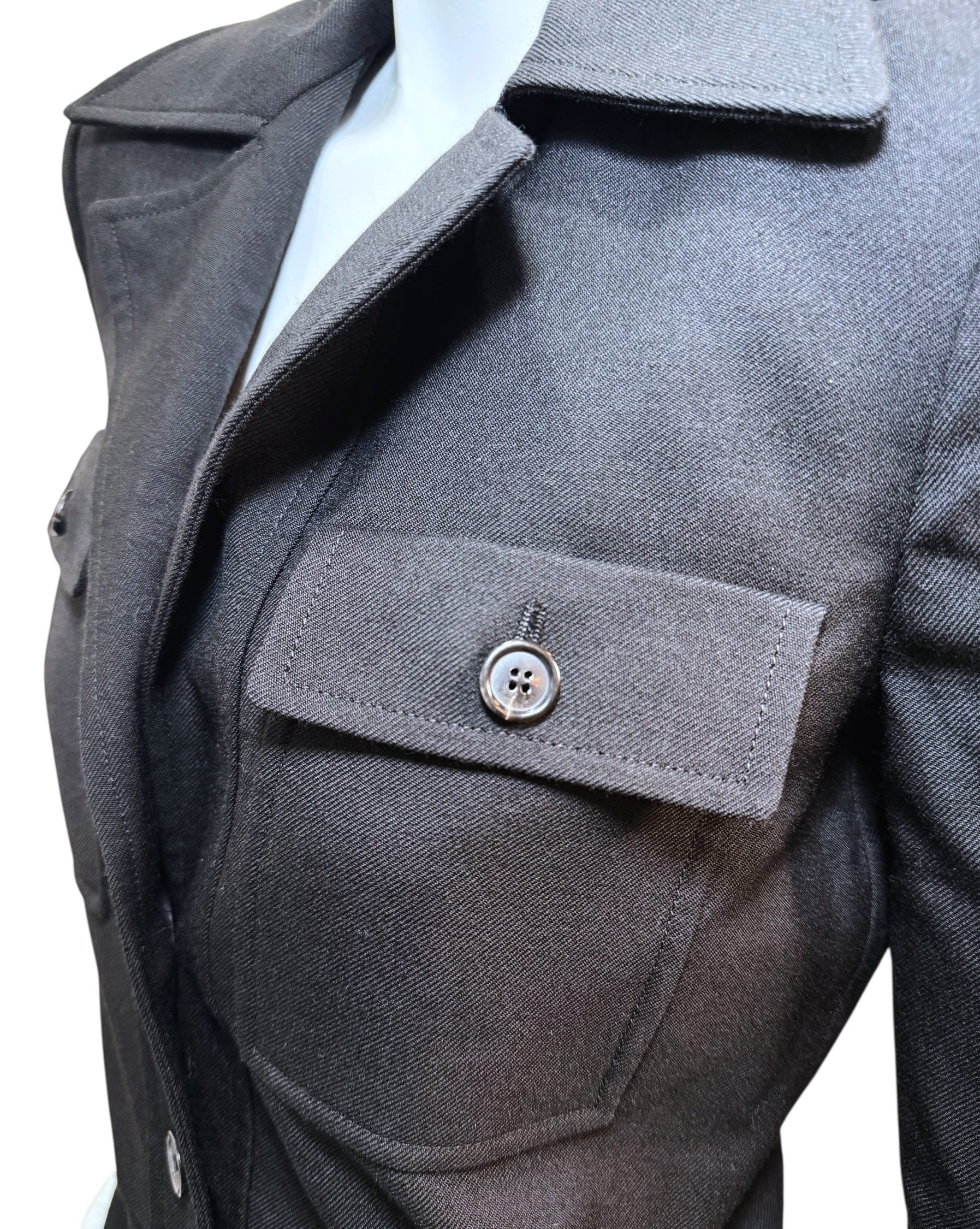 Close-up of Saint Laurent FW22 black wool jumpsuit chest pocket with buttoned flap and precise stitching.