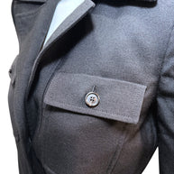 Close-up of Saint Laurent FW22 black wool jumpsuit chest pocket with buttoned flap and precise stitching.