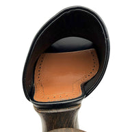 Interior detail of an Alaïa La Sculpture black leather mule showing the cognac leather footbed, decorative perforations and heel construction.
