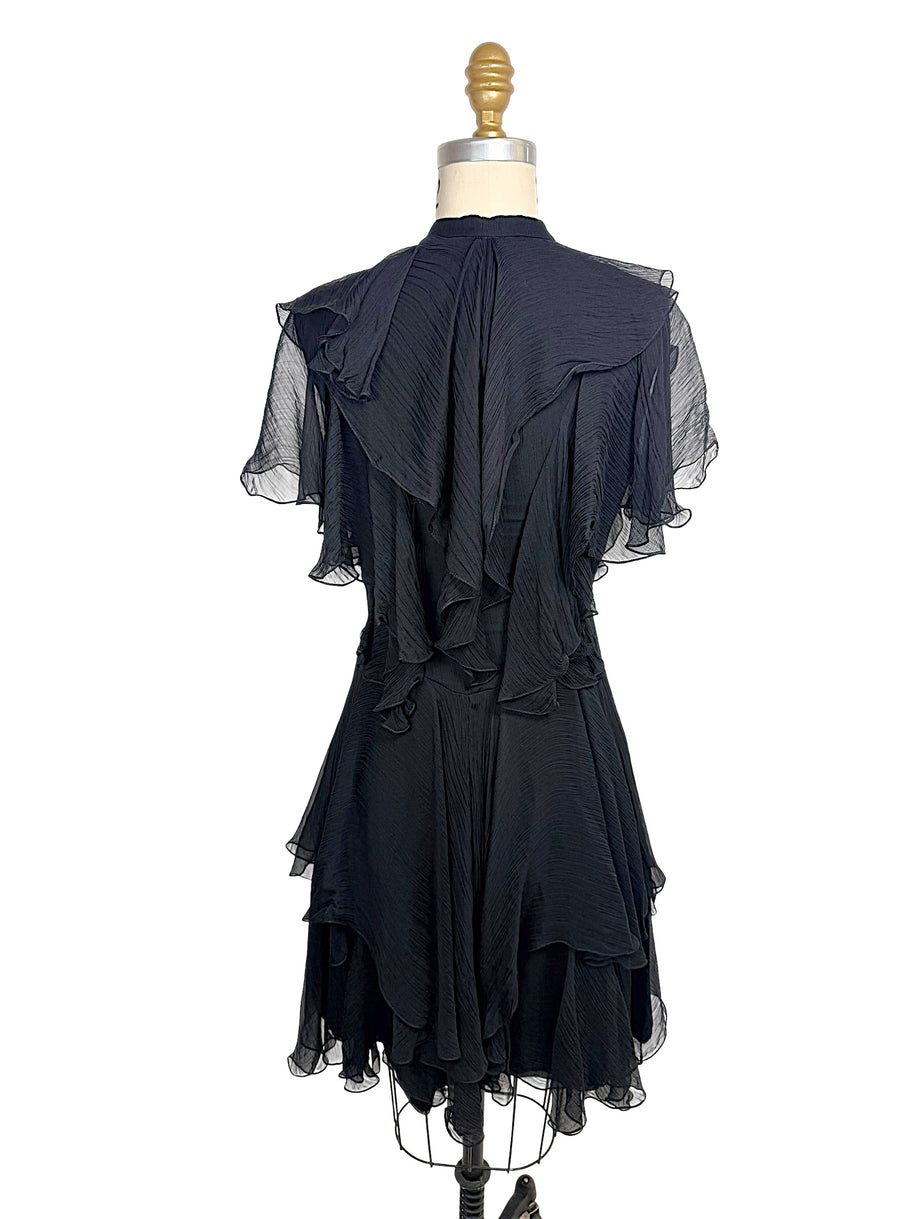 Rear view of the Alexander McQueen Pre-Fall 2016 black silk chiffon dress featuring cascading back ruffles, pleated chiffon, and layered asymmetrical hem.