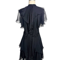 Rear view of the Alexander McQueen Pre-Fall 2016 black silk chiffon dress featuring cascading back ruffles, pleated chiffon, and layered asymmetrical hem.