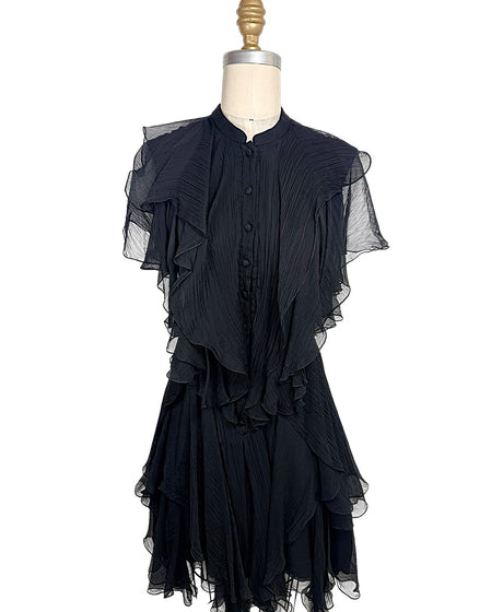 Alexander McQueen Pre-Fall 2016 black silk chiffon dress featuring pleated construction, cascading ruffles, sheer flutter sleeves, and an asymmetrical layered hem, front full view.