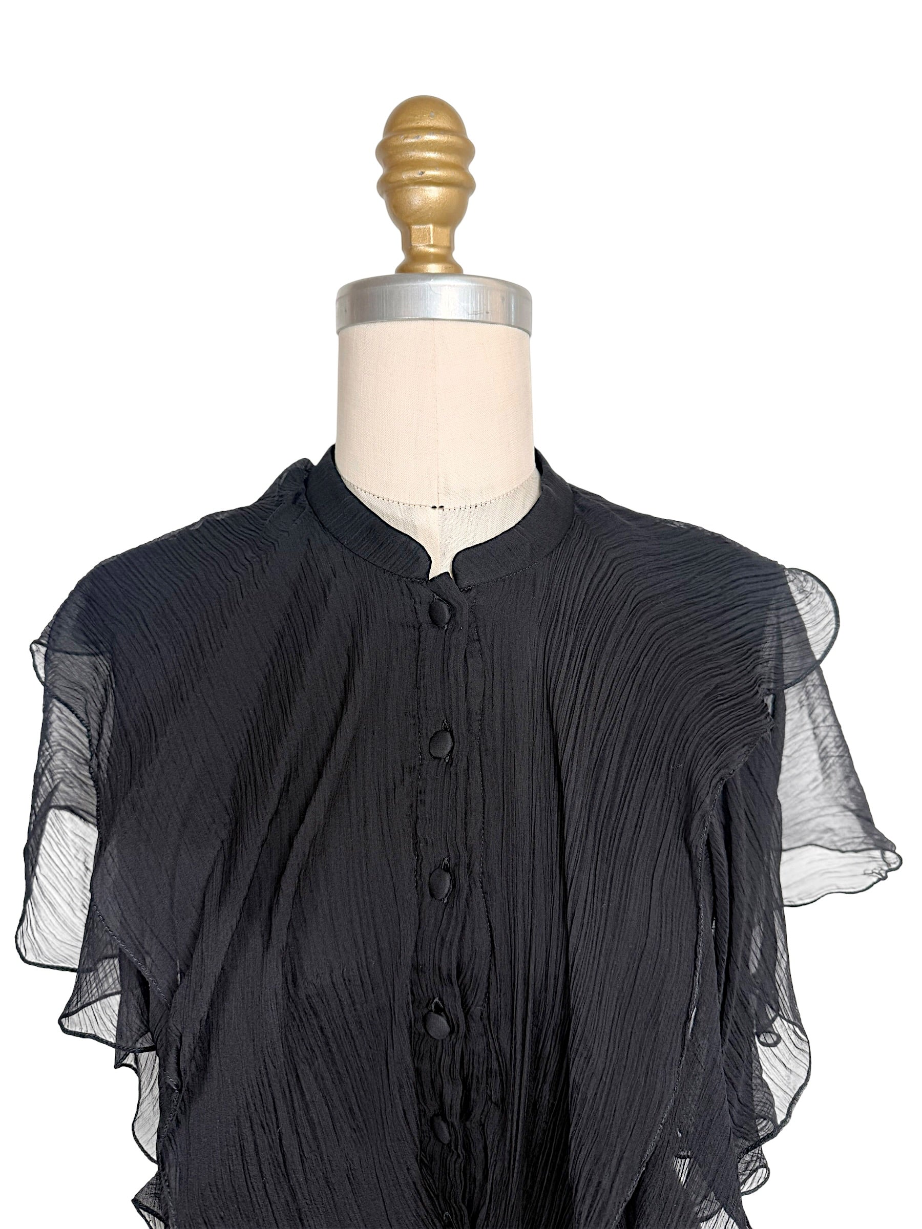 Detailed view of the Alexander McQueen Pre-Fall 2016 dress showing the stand collar, covered silk buttons, pleated silk chiffon, and cascading front ruffles.