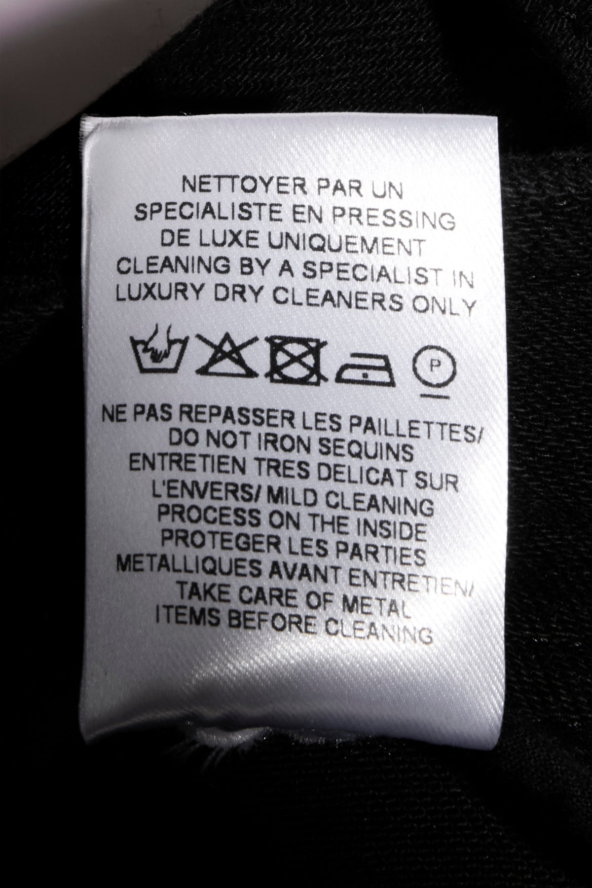 Balmain black sequin pants interior care label with sequin cleaning and care instructions