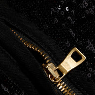 Close-up of gold-tone zipper and black sequin embellishment on Balmain pants