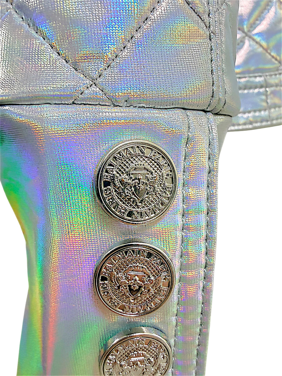 Close-up detail of embossed Balmain Paris crest buttons on the holographic silver cuff of the Fall 2018 runway jacket