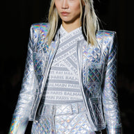 Detail of Balmain Fall Winter 2018 Look 8 runway presentation showing the holographic silver quilted jacket, structured shoulders and patch pockets