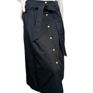 Angled front view of Celine black cotton midi skirt featuring gold-tone buttons, high waist, and coordinating fabric tie belt.