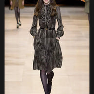 Celine Fall Winter 2020 runway Look 15 featuring a brown polka dot high-neck silk midi dress with ruffled front, long sleeves and pleated skirt.