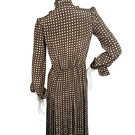 Rear view of Celine Fall 2020 runway polka dot silk midi dress showing gathered waist, long sleeves and finely pleated skirt.