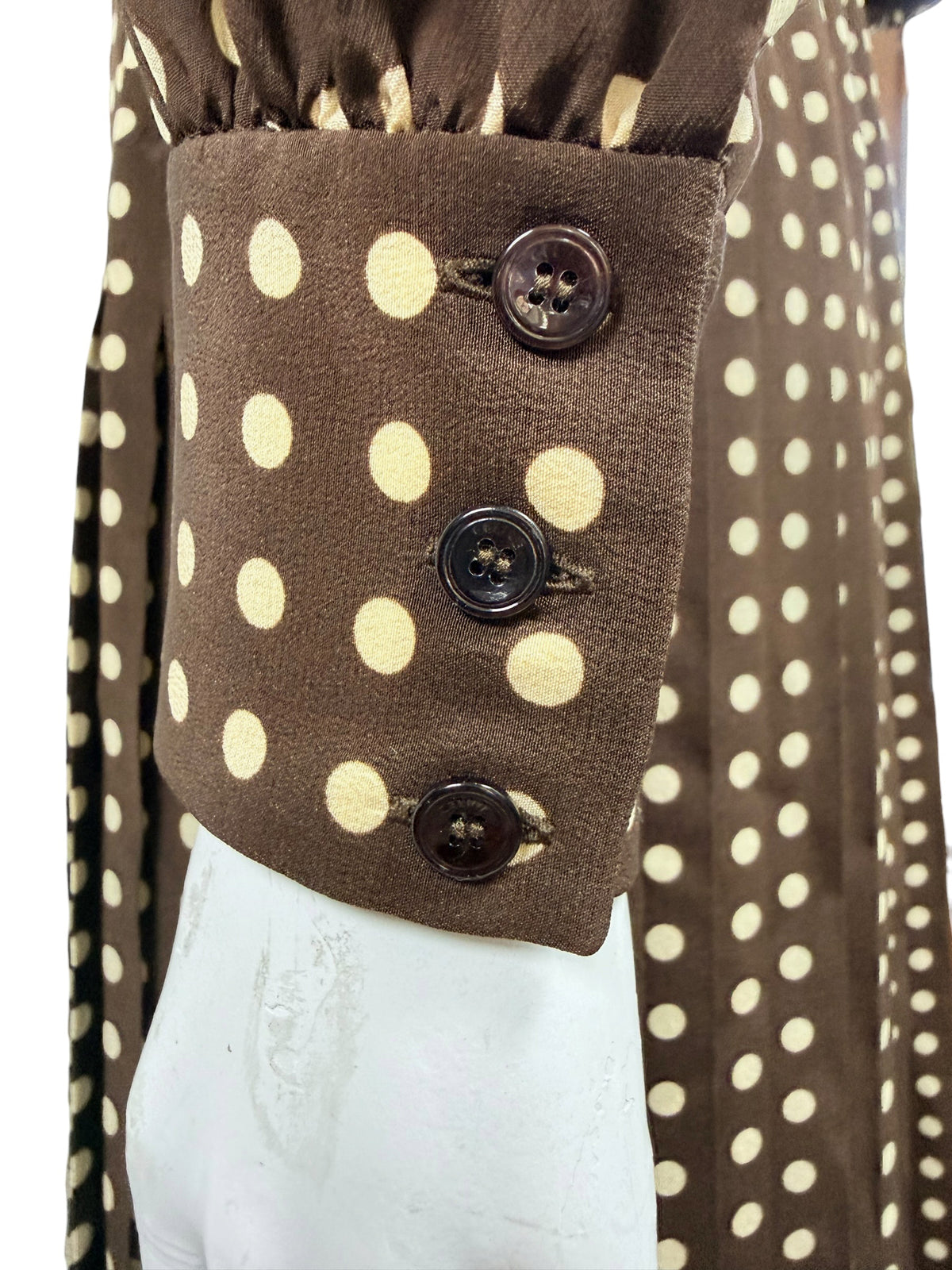 Close-up of the three-button sleeve cuff on Celine FW20 chocolate brown silk dress with cream polka dot print.