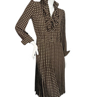 Full-length front view of Celine Fall 2020 Look 15 silk dress with open ruffled neckline, fitted waist and flowing pleated polka dot skirt.