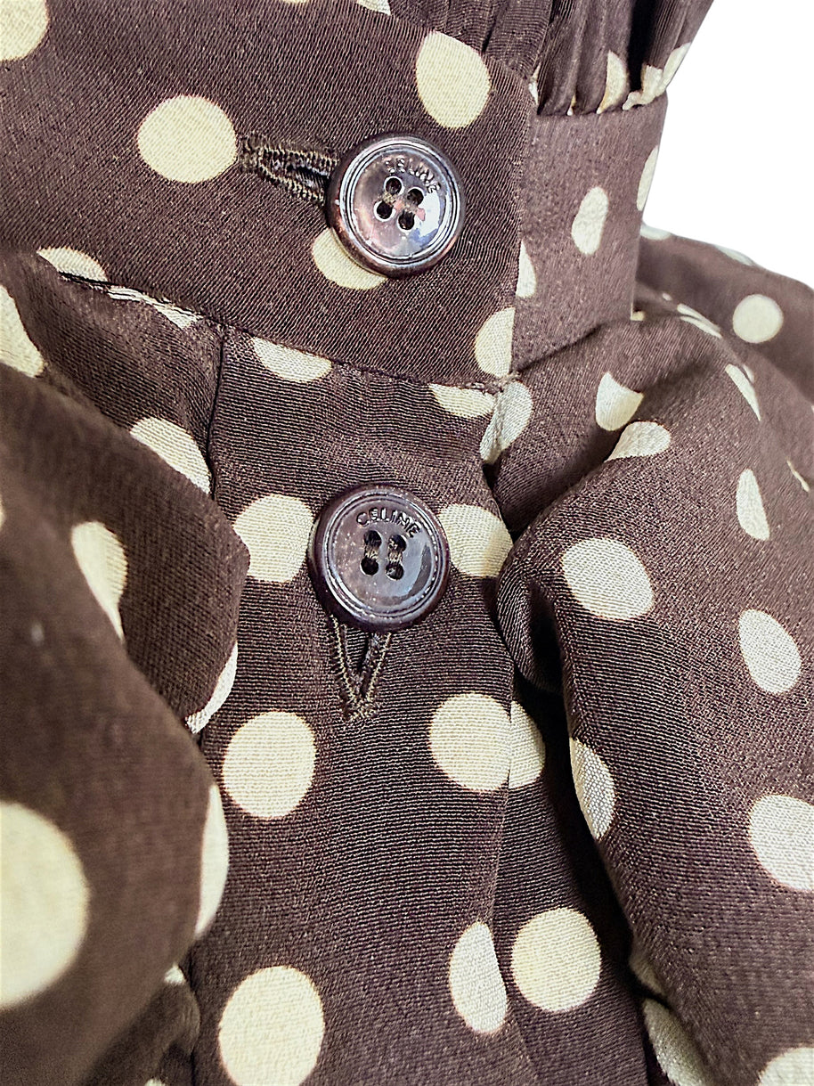 Macro detail of Celine-engraved buttons on chocolate brown and cream polka dot silk fabric from the Fall 2020 runway dress.