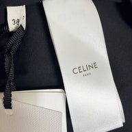 Close-up of Celine Paris woven designer label and French size 38 tag inside black cotton belted midi skirt with original retail tags attached.