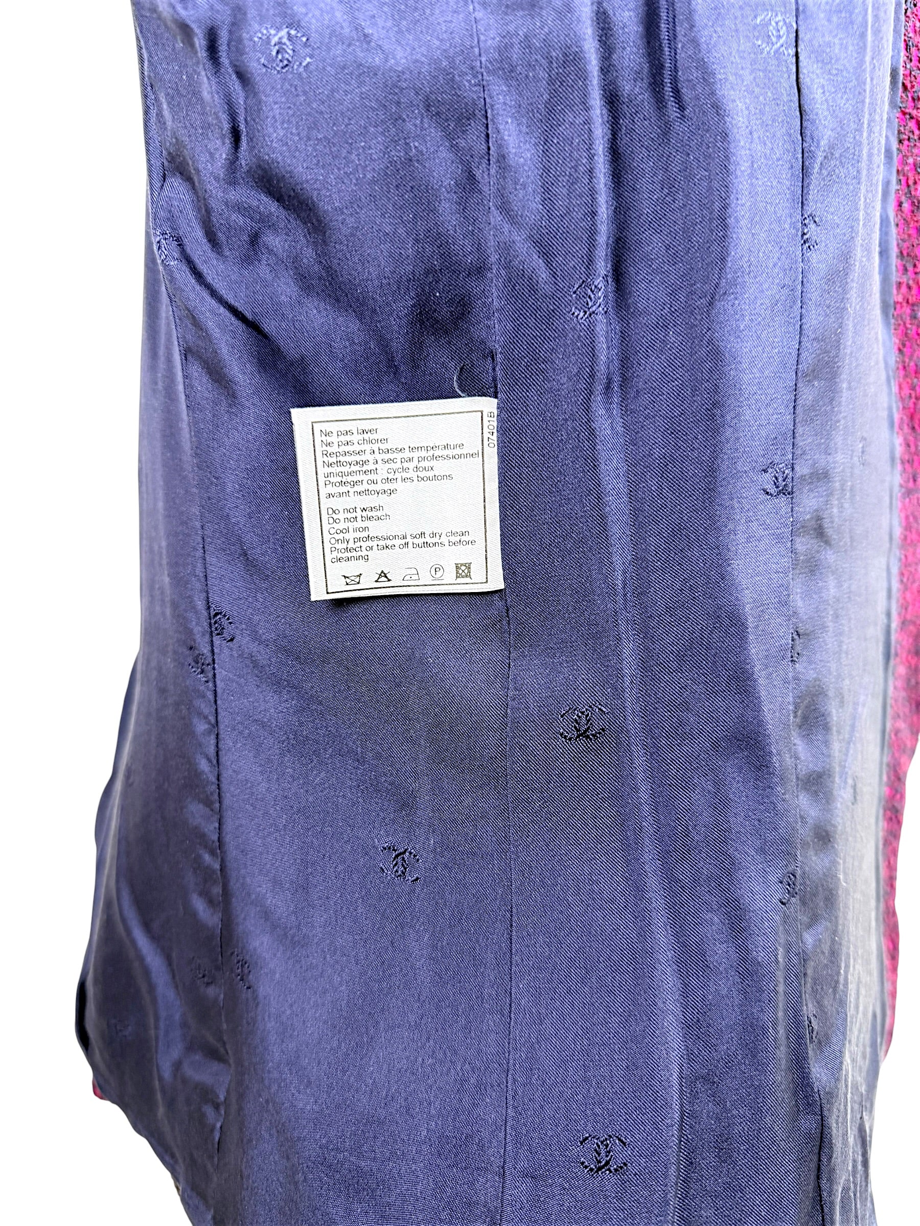Interior navy silk CC monogram lining of Chanel 1998 tweed jacket with attached care instruction tag