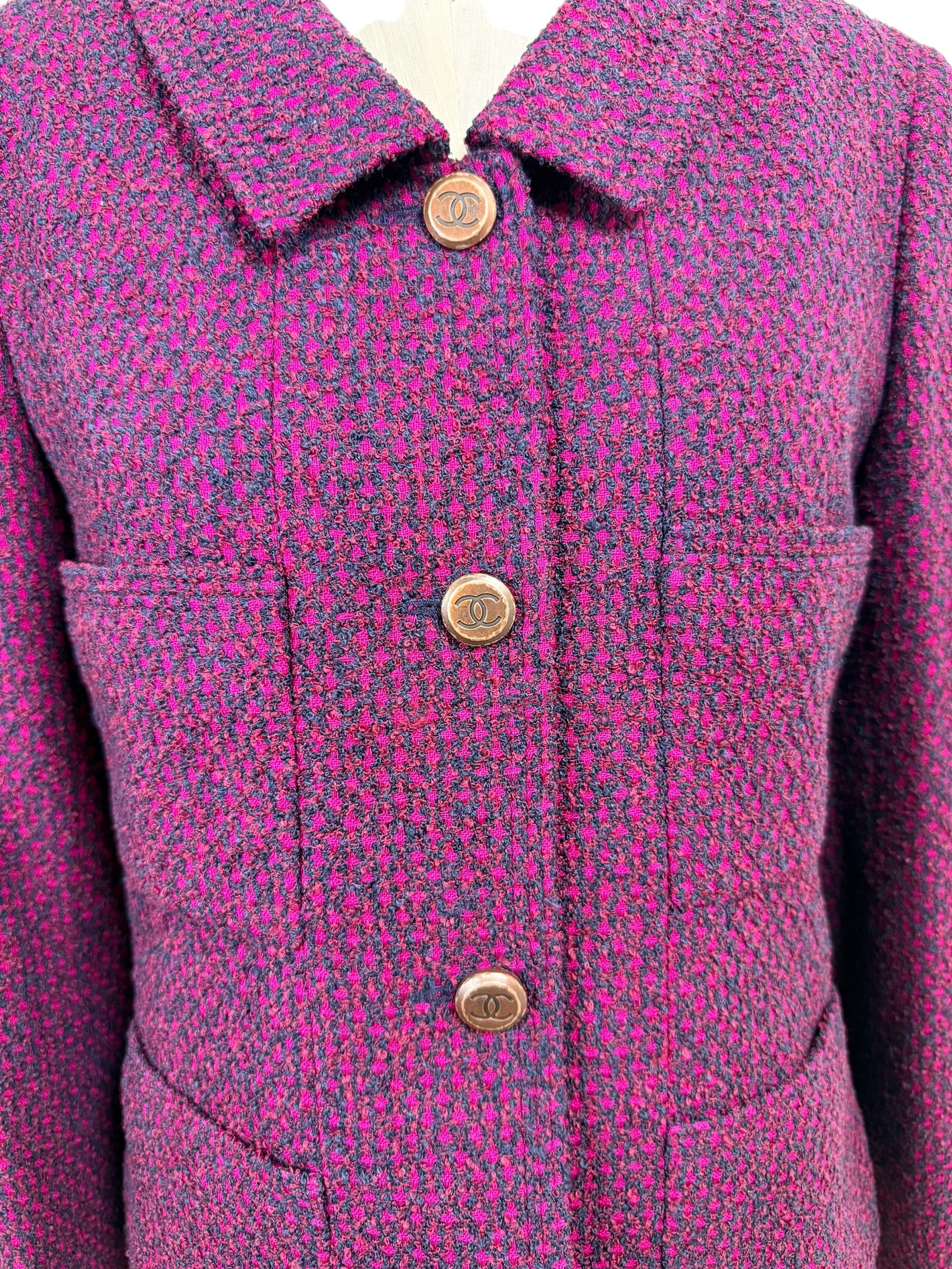 Close-up detail of Chanel 1998 fuchsia and navy tweed fabric with signature engraved CC logo front buttons and patch pockets