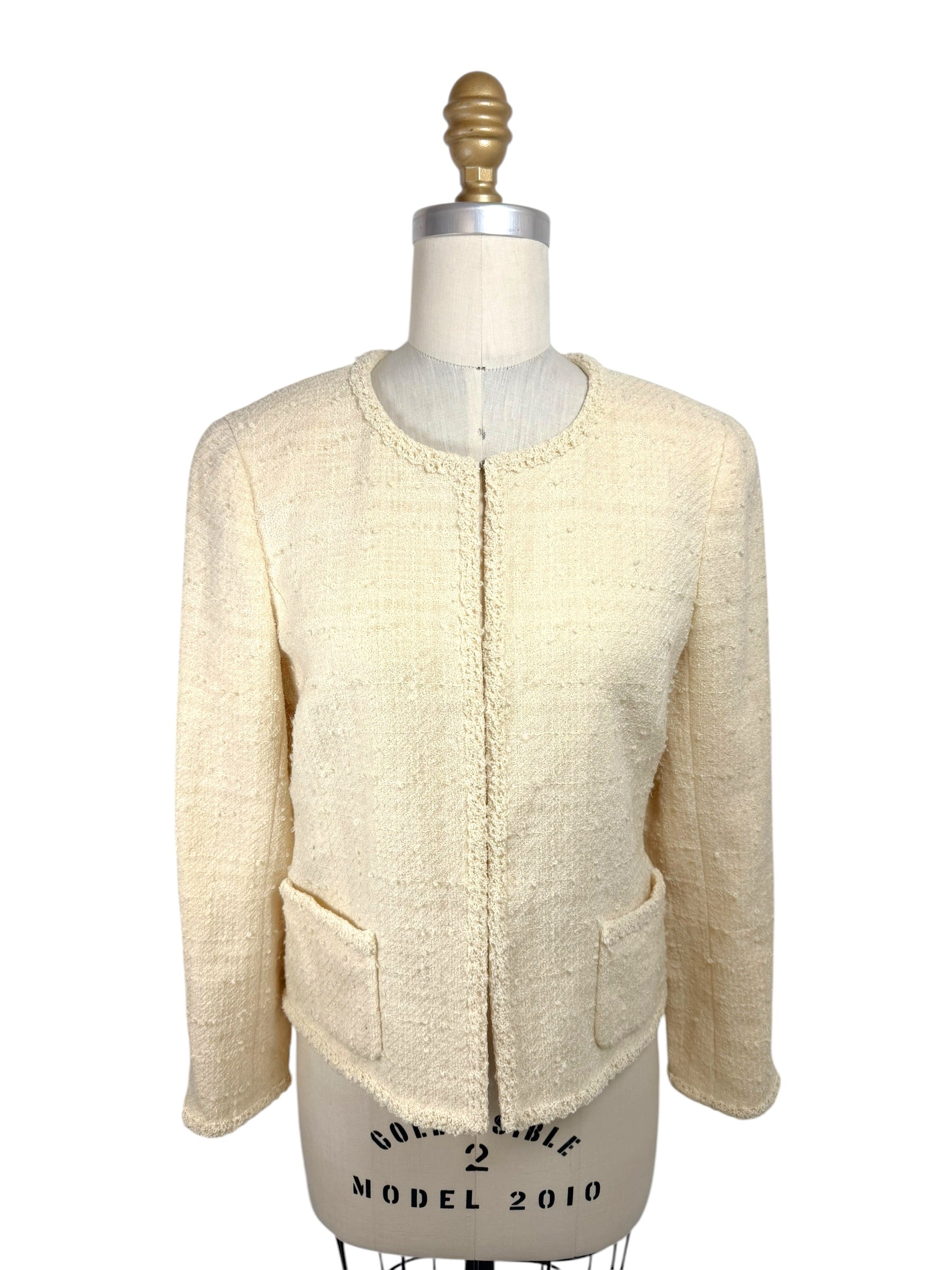 Vintage 1998 Chanel ivory bouclé tweed jacket front view with fringe trim and patch pockets on mannequin