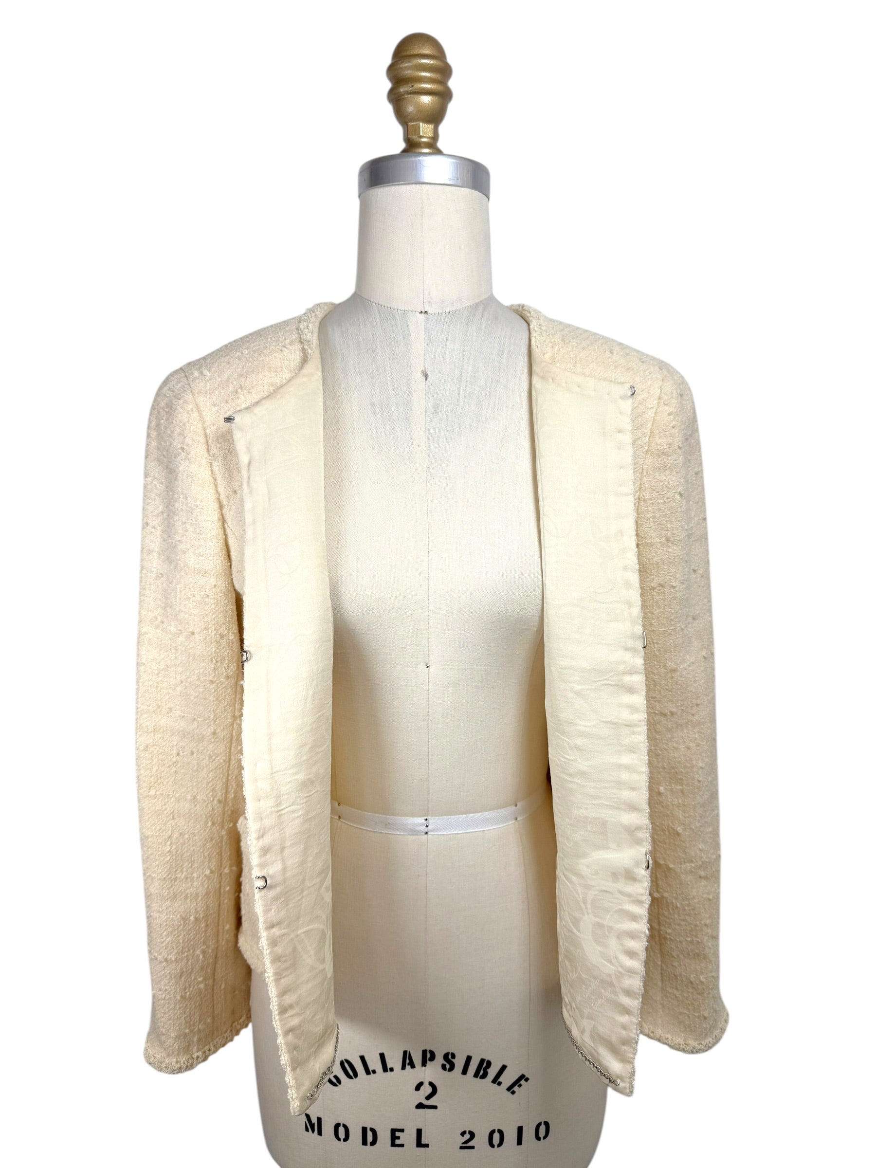 Interior view of 1998 Chanel ivory bouclé jacket with silk camellia jacquard lining and hook closures