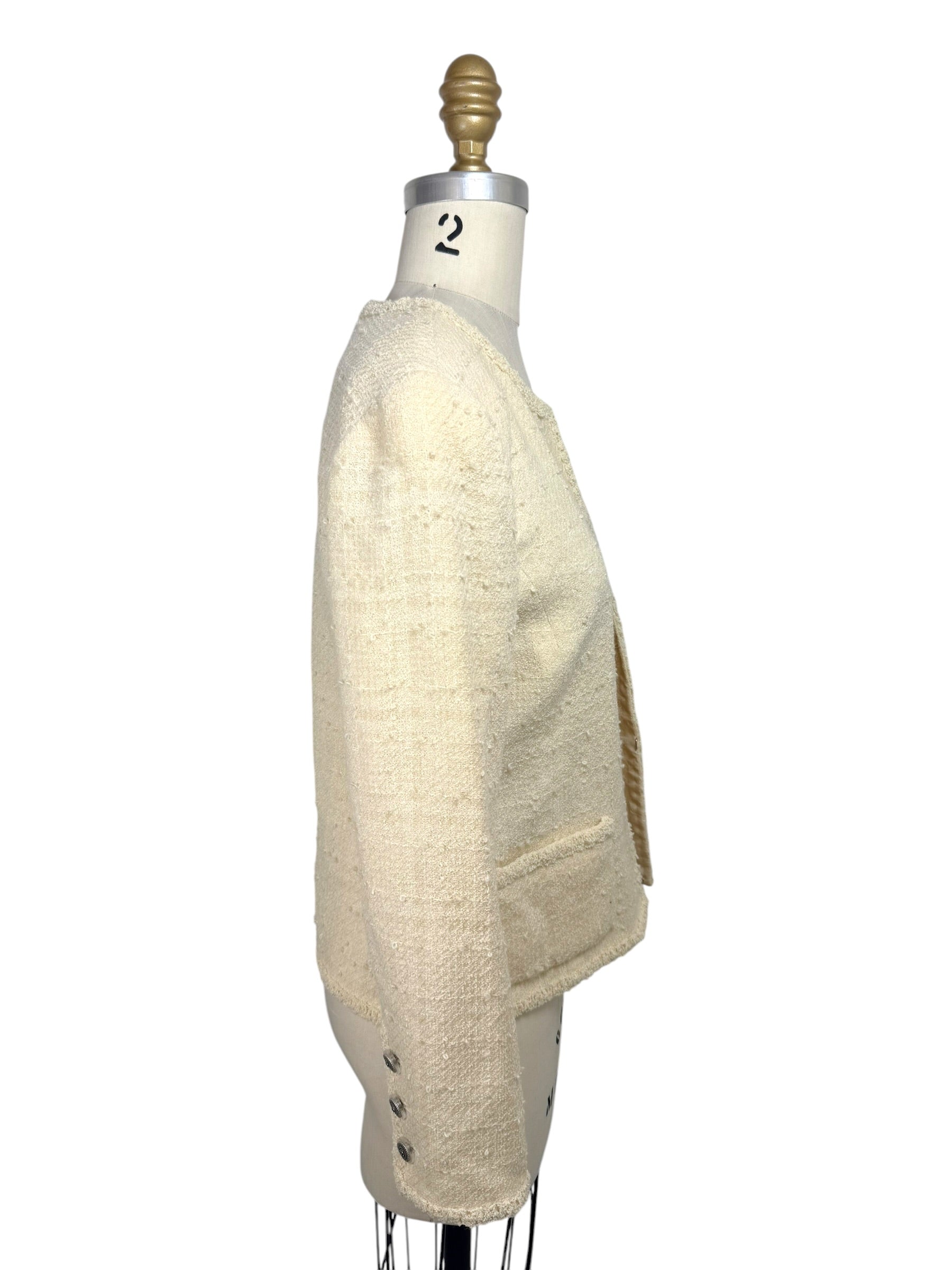 Side profile of vintage Chanel ivory bouclé tweed jacket with textured fabric and cropped silhouette