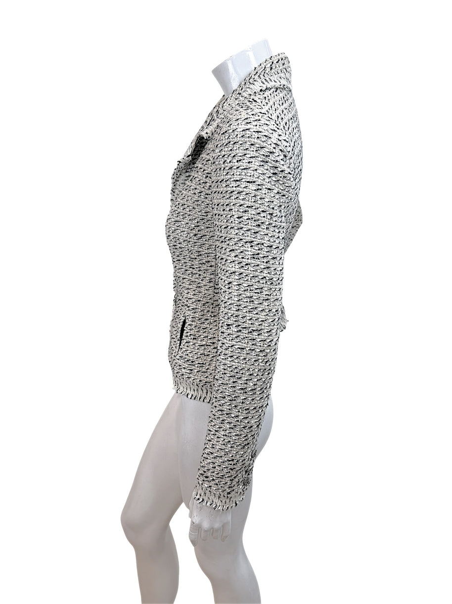 Left side profile of Chanel 2004 ivory black Lesage tweed jacket with structured tailoring and fringe hem
