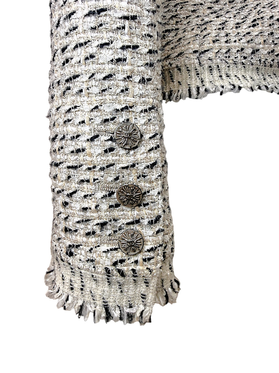Close-up of Chanel logo sleeve buttons and fringe cuff detail on 2004 Lesage tweed jacket