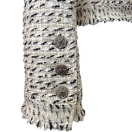 Close-up of Chanel logo sleeve buttons and fringe cuff detail on 2004 Lesage tweed jacket