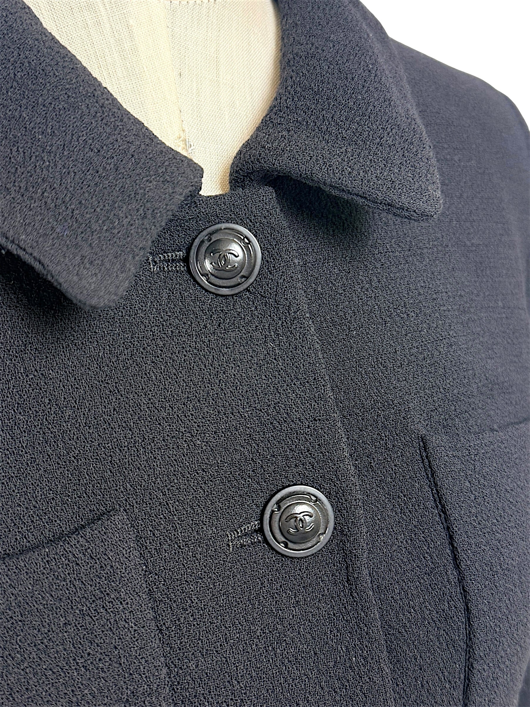 Detailed close-up of Chanel CC logo buttons on textured black vintage Chanel jacket