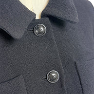 Detailed close-up of Chanel CC logo buttons on textured black vintage Chanel jacket