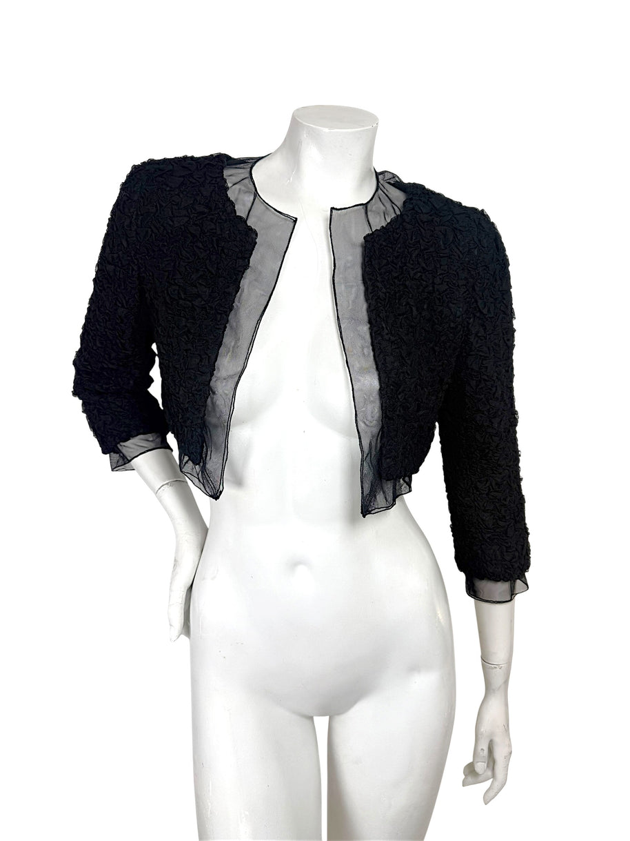 Full front view of Chanel black cropped bolero jacket with ruched texture and sheer silk chiffon panels
