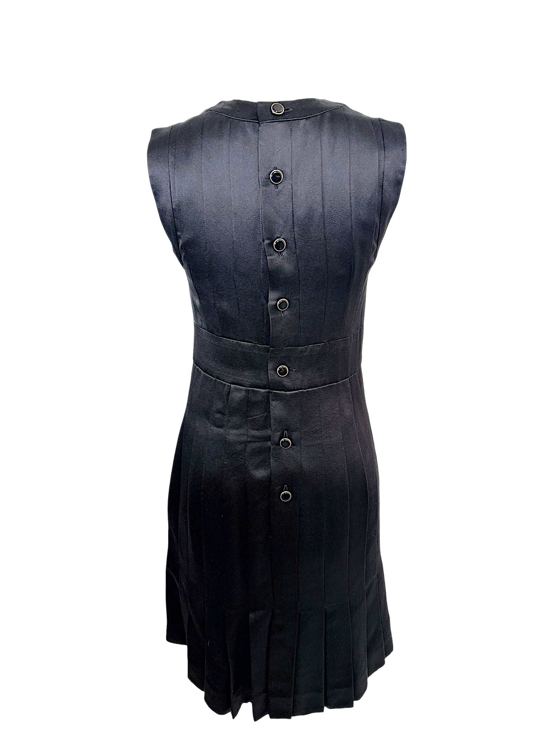 Rear view of vintage Chanel black satin pleated dress featuring signature Chanel logo button closure.