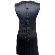 Rear view of vintage Chanel black satin pleated dress featuring signature Chanel logo button closure.