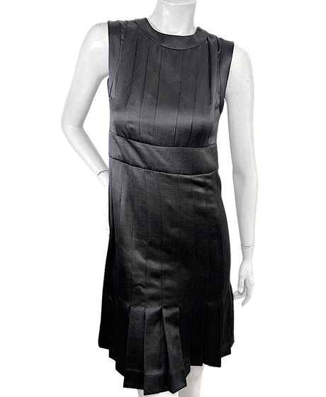 Vintage Chanel black satin sleeveless pleated dress front view with sculpted neckline and fitted waist detail.