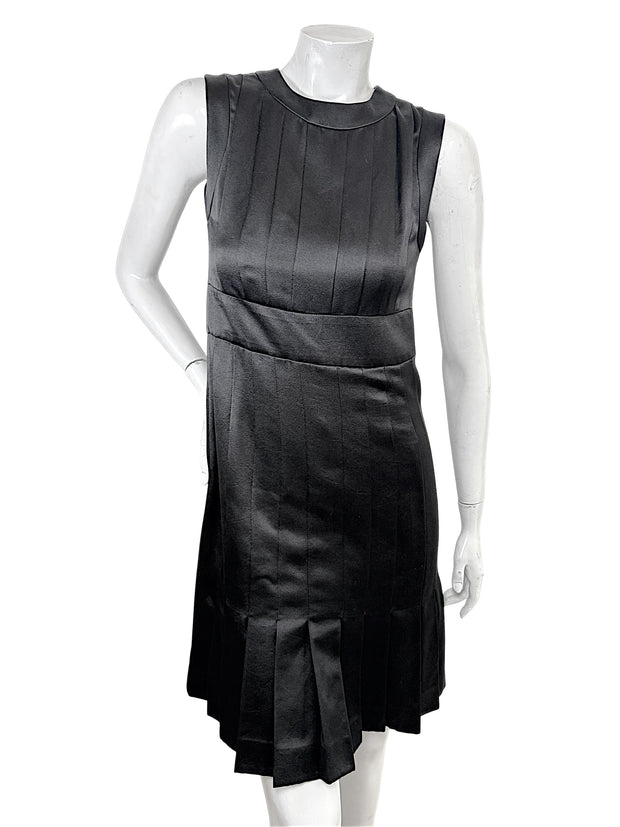 Vintage Chanel black satin sleeveless pleated dress front view with sculpted neckline and fitted waist detail.