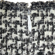Chanel CC zipper pull detail on black and white tweed fabric