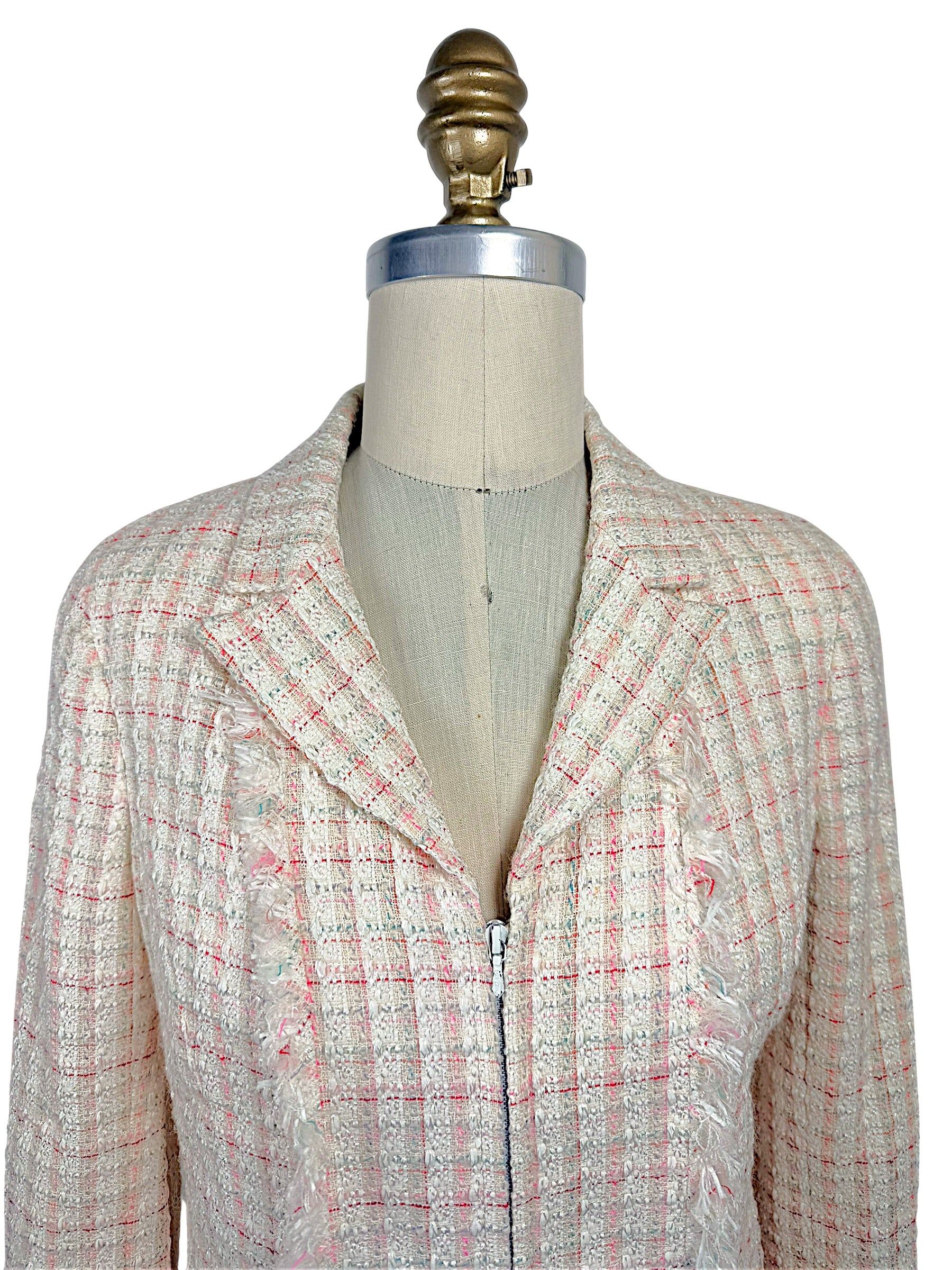 Close-up of Chanel Cruise 2004 fantasy tweed jacket showing textured ivory bouclé, concealed zip closure, frayed trim and tailored notched collar.