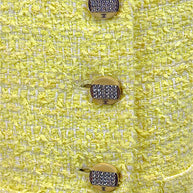 Close-up detail of crystal CC logo buttons on Chanel Cruise 2012 yellow bouclé tweed runway jacket