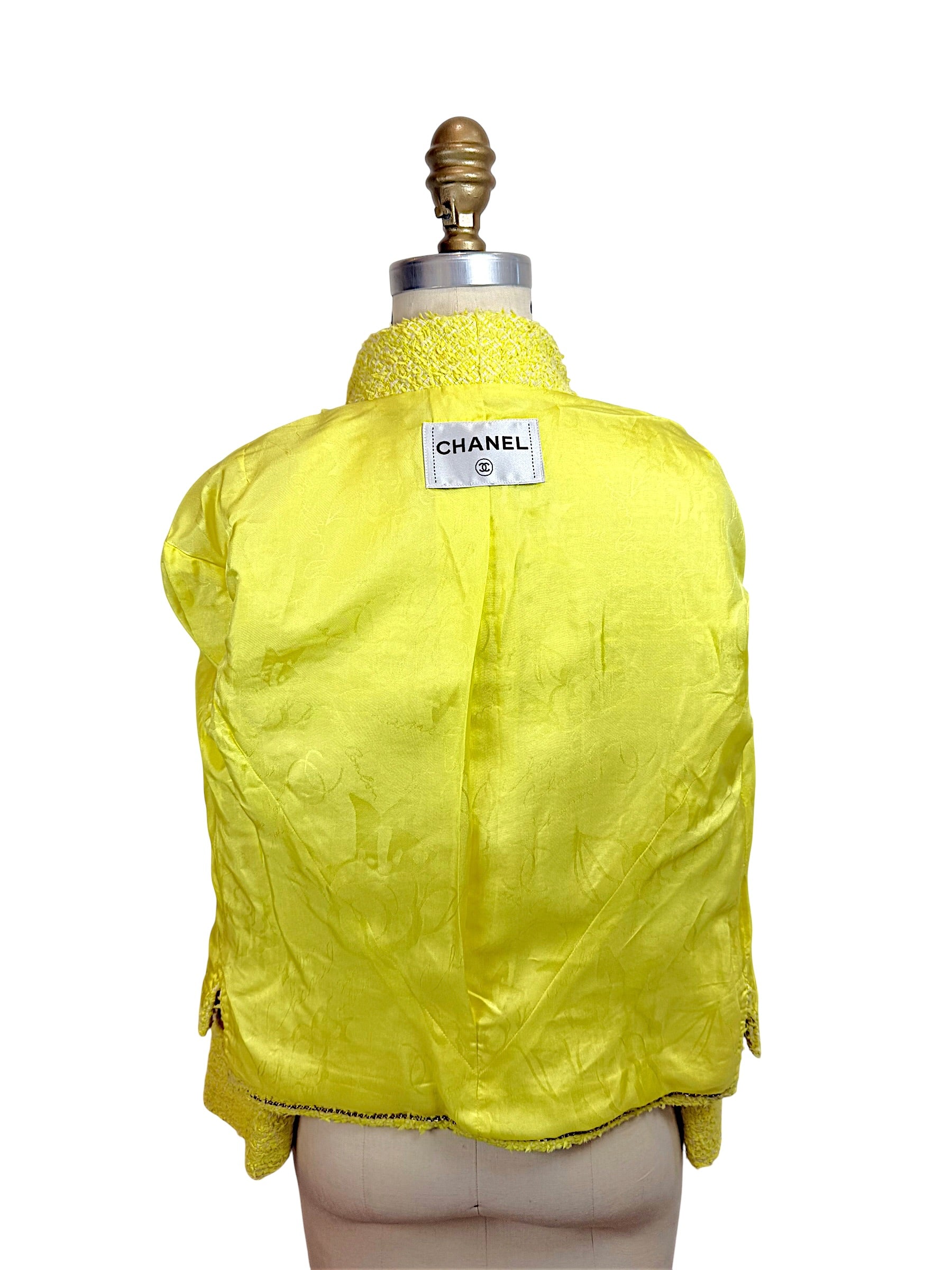 Interior view of Chanel Cruise 2012 yellow tweed jacket featuring signature CC jacquard silk lining