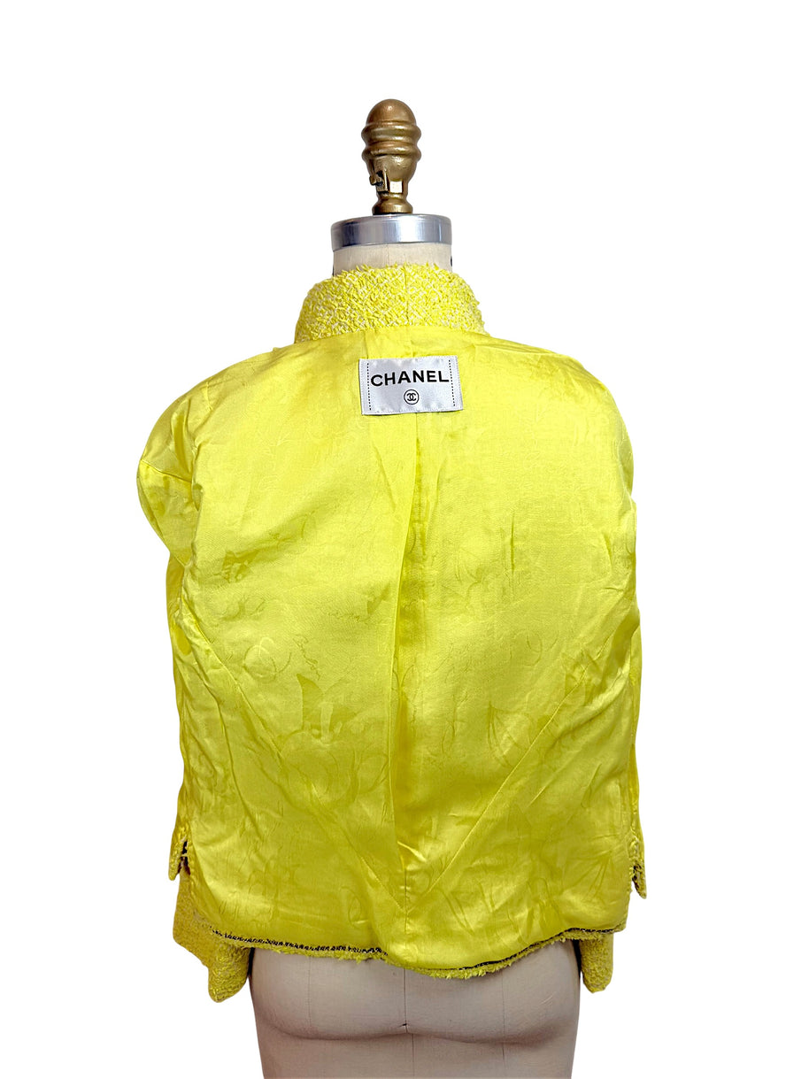 Interior view of Chanel Cruise 2012 yellow tweed jacket featuring signature CC jacquard silk lining