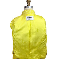 Interior view of Chanel Cruise 2012 yellow tweed jacket featuring signature CC jacquard silk lining