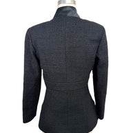 Rear view of the Chanel Cruise 2017 textured black jacket showcasing the fitted tailoring, center seam construction, and satin collar.