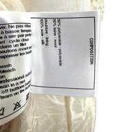 Interior composition and care label detailing the premium fabric blend and silk lining used in the Chanel Cruise 2019 Runway Look 26 ivory fantasy tweed jacket.