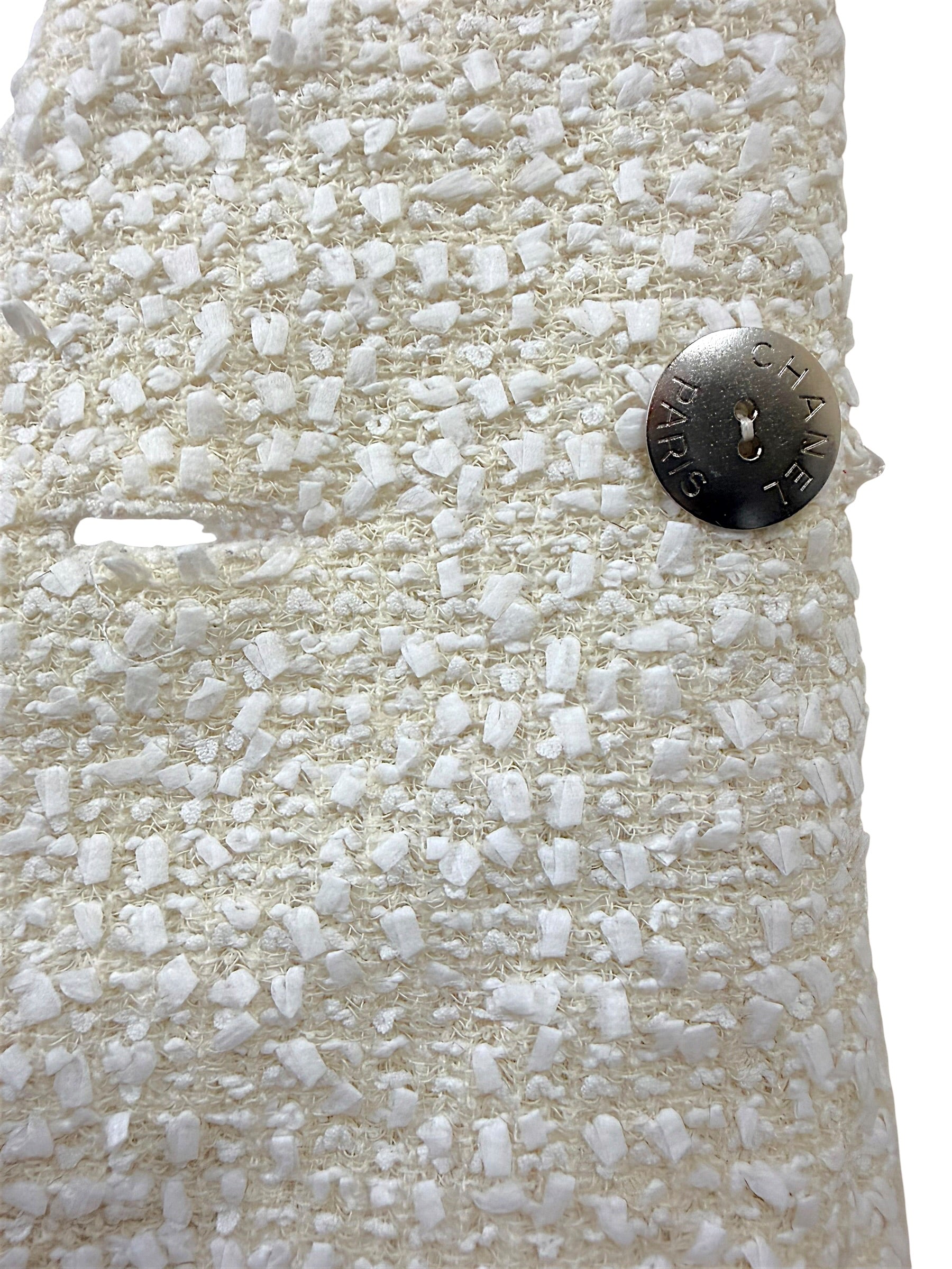 Interior silver-tone Chanel Paris logo button securing the front closure of the authentic Chanel Cruise 2019 Runway Look 26 ivory fantasy tweed jacket.