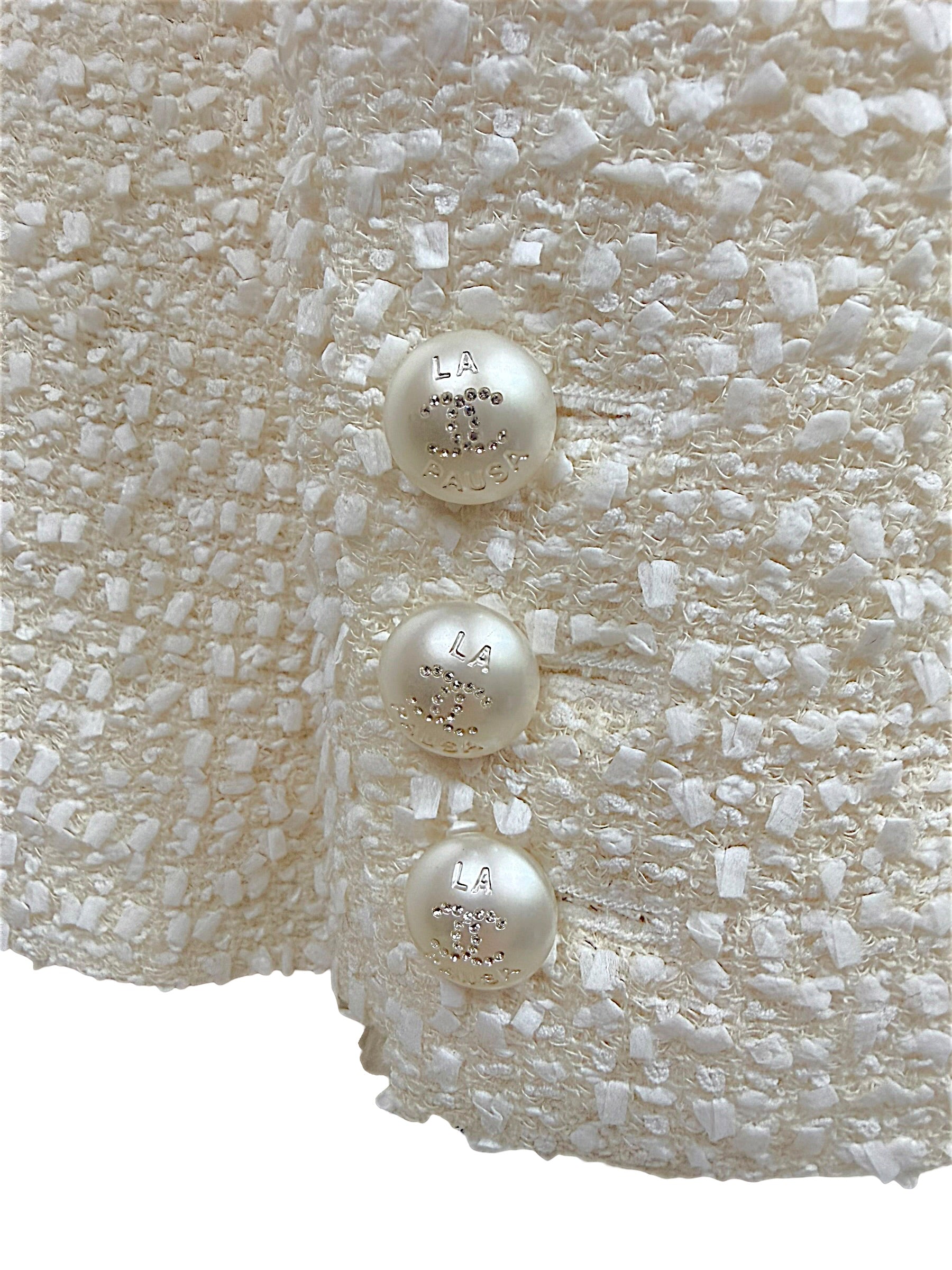 Close-up of the three original pearl-effect La Pausa CC buttons on the sleeve cuff of the Chanel Cruise 2019 Runway Look 26 fantasy tweed jacket.