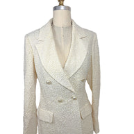 Front view of an authentic Chanel Cruise 2019 Runway Look 26 ivory fantasy tweed double-breasted jacket with oversized shawl lapels and pearl-effect La Pausa CC buttons.