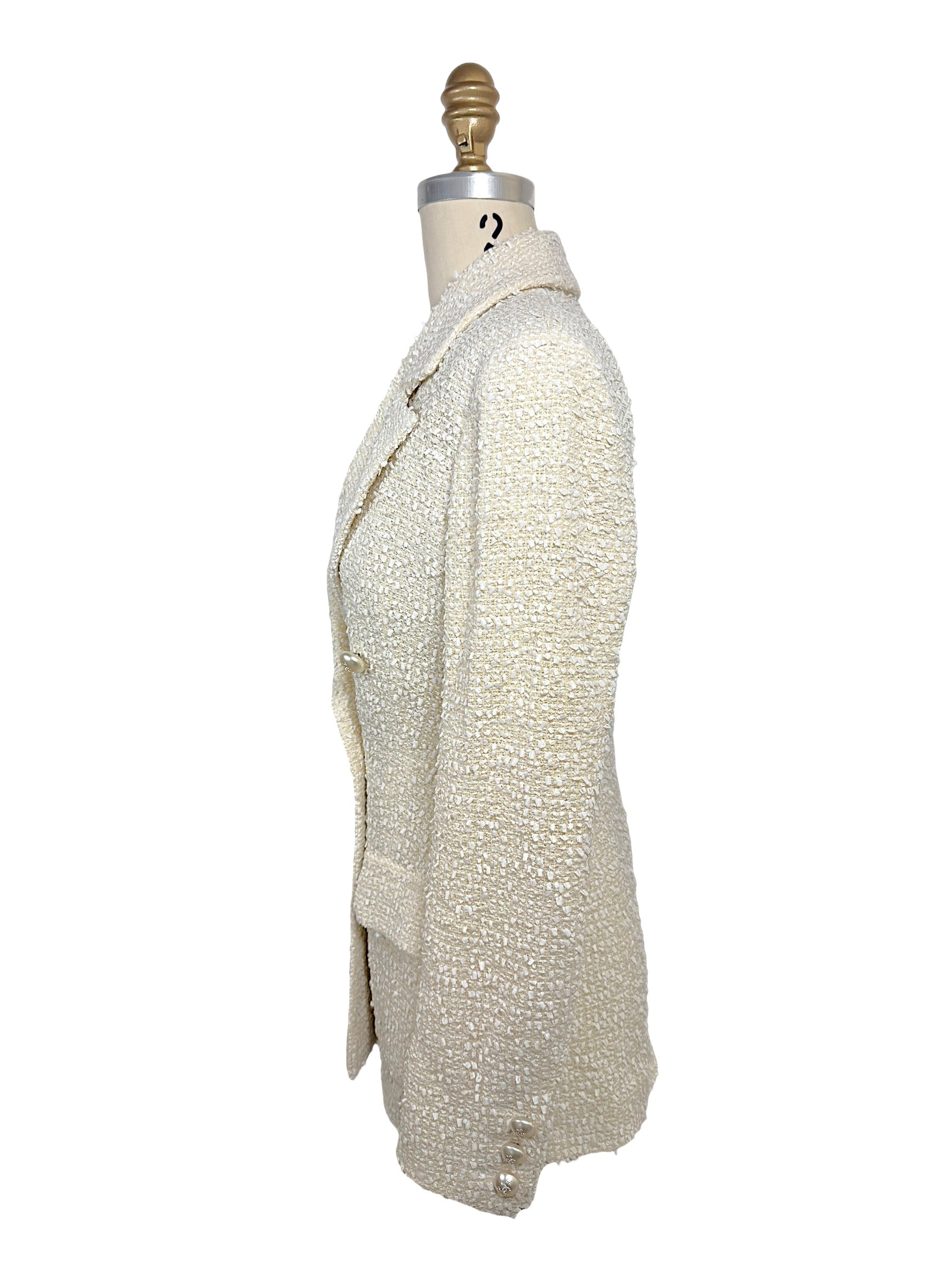 Left side profile of the authentic Chanel Cruise 2019 ivory fantasy tweed runway jacket illustrating the tailored fit and textured bouclé construction.